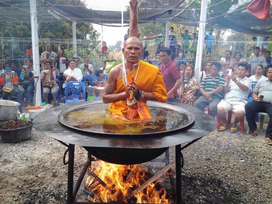 Thai monk meditates in a pot of boiling oil on fire