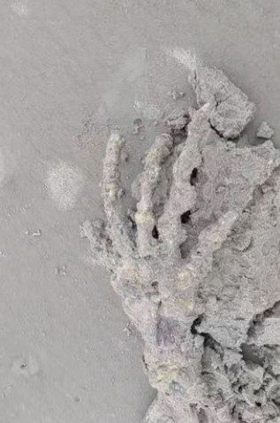 The hand is covered in sand. 